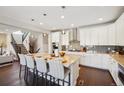Open-concept kitchen showcasing modern cabinetry, stainless appliances, granite counters, and island with seating at 17829 W 95Th Pl, Arvada, CO 80007