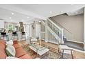 Open concept living area with view of a staircase, hardwood flooring, and access to kitchen, great for entertaining at 6382 W Byers Pl, Lakewood, CO 80226