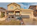 Two-story house with beige siding, stone accents, and a two-car garage at 13717 Ashgrove Cir, Parker, CO 80134