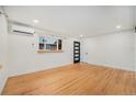 Bright living room boasts hardwood floors, window, modern door, and mini-split system for efficient heating and cooling at 1111 Monroe St, Denver, CO 80206