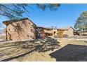 Rear view of brown apartments with brick accents and blue sky at 3335 S Ammons St # 103, Lakewood, CO 80227