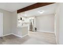 Bright white kitchen with stainless steel appliances and gray backsplash at 3335 S Ammons St # 103, Lakewood, CO 80227