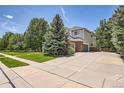 Residential two-story home featuring a spacious driveway, mature trees, and well-kept lawn at 13901 Quail Ridge Dr, Broomfield, CO 80020