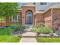 Inviting front entrance with brick archway, well-maintained landscaping, and a welcoming walkway at 13901 Quail Ridge Dr, Broomfield, CO 80020