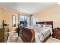 Comfortable bedroom features soft carpet, a modern window, and a stately wooden bed frame at 16333 E Carolina Dr, Aurora, CO 80017