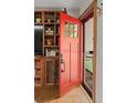 Inviting entryway featuring a red front door, rustic wood built-ins, and hardwood floors at 8764 W 95Th Ave, Broomfield, CO 80021