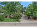 Brick ranch home with a spacious lawn, driveway, and mature trees at 1746 Shavano St, Longmont, CO 80504