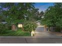 A single story home with a brick facade, a well-manicured lawn, and mature trees at dusk at 1746 Shavano St, Longmont, CO 80504