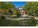 Beautiful home featuring mature trees and landscaping, a large patio, and inviting outdoor space at 4880 Tall Horse Trl, Sedalia, CO 80135