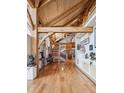 Grand foyer features hardwood floors, an intricate staircase, and beautiful wood beam architecture at 4880 Tall Horse Trl, Sedalia, CO 80135