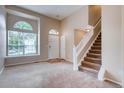 Inviting living room with neutral-toned walls, large window, and a staircase leading to the upper level at 2792 S Ceylon St, Aurora, CO 80013