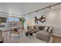Comfortable living room boasts hardwood floors, large windows with a city view, and stylish, neutral-toned furniture at 4800 E Hale Pkwy # 712N, Denver, CO 80220