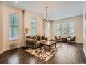 Bright living room featuring hardwood floors, area rug, neutral walls, and a decorative chandelier at 2775 California St, Denver, CO 80205