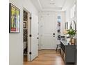 Bright entryway featuring hardwood floors, a white front door, and a half-bathroom at 1039 Highview Dr, Erie, CO 80516