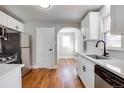 Modern kitchen features white cabinets, stainless appliances, and beautiful hardwood floors at 2101 S Lafayette St, Denver, CO 80210