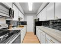 Modern galley kitchen with white cabinets, quartz countertops and gold fixtures at 1020 15Th St # 27E, Denver, CO 80202