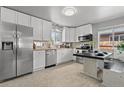 Updated kitchen features stainless steel appliances, white cabinetry, butcher block countertop, and breakfast bar at 3667 Hudson St, Denver, CO 80207