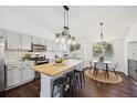Light and bright kitchen with white cabinets, butcher block island, and eat-in dining at 9763 Cove Creek Dr, Highlands Ranch, CO 80129