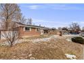 Side view of brick ranch home with a yard at 1441 E 84Th Pl, Denver, CO 80229