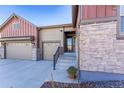 Welcoming front entrance featuring stone accents, a modern door, and well-maintained landscaping at 7770 Owl Creek Cir, Littleton, CO 80125