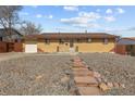 Ranch-style home with stone landscaping and a well-maintained lawn at 1001 Dakin St, Denver, CO 80221