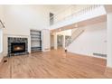 Spacious living room with a fireplace, built-in shelves, and staircase leading to the second floor at 5294 S Espana St, Centennial, CO 80015