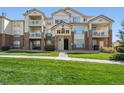 Three-story building with balconies, landscaping, and brick accents at 5733 N Gibralter Way # 3-202, Aurora, CO 80019