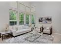 Bright living room with soaring ceilings, large windows and neutral decor at 2500 Lexington St, Lafayette, CO 80026