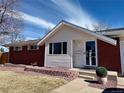 Well-maintained home exterior featuring brick accents, tidy landscaping, and inviting entrance at 5986 S Cook St, Littleton, CO 80121