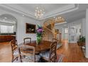 Traditional dining room features a wood table, patterned chairs, a chandelier and adjacent staircase at 7084 Moss Ct, Arvada, CO 80007