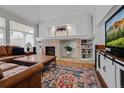 Inviting living room featuring a brick fireplace, and large leather sofa at 7084 Moss Ct, Arvada, CO 80007