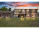 Brick home showcasing a backyard with a deck, stairs, a well-kept lawn, and mature trees at 8759 Seton St, Westminster, CO 80031