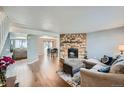 Inviting living room features a stone fireplace, wood floors, and an open layout to the kitchen at 68 S Moline St, Aurora, CO 80012