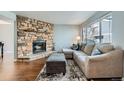 A cozy living room featuring a stone fireplace and ample natural light from a large window at 68 S Moline St, Aurora, CO 80012