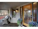 Inviting covered porch with comfortable seating area and stylish decor, including potted flowers at 1334 Solitude Ln, Evergreen, CO 80439