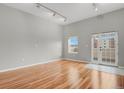 Bright living room with hardwood floors, neutral walls, and a door to a balcony for outdoor enjoyment at 1780 N Washington St # 405, Denver, CO 80203