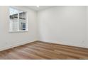 Cozy bedroom showcasing hardwood floors, white walls, and a window allowing natural light at 8230 Snake River St, Littleton, CO 80125