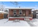 Inviting brick home featuring a cozy covered porch with seating area at 4518 Vallejo St, Denver, CO 80211