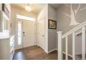 Bright foyer featuring hardwood floors, a front door with sidelights, and staircase with white railing at 190 Olympia Ave, Longmont, CO 80504