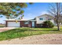 Well maintained home featuring a spacious garage, manicured lawn and a combination of brick and vinyl siding at 29881 E 128Th Ave, Commerce City, CO 80022