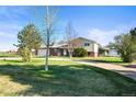 Charming home featuring a spacious front yard, long driveway and a combination of brick and vinyl siding at 29881 E 128Th Ave, Commerce City, CO 80022