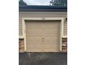 Attached single-car garage featuring paneled door and stone accents on a well-maintained home exterior at 8358 S Independence Cir # 105, Littleton, CO 80128
