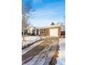 Front view of a ranch home with a driveway, snow on the ground at 10401 W Lehigh Ave, Denver, CO 80235