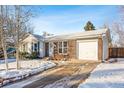 Ranch style home with driveway and attached garage, winter scene at 10401 W Lehigh Ave, Denver, CO 80235