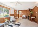 Inviting living room featuring wood paneling, a cozy wood-burning stove, and a large window with scenic views at 10039 S Turkey Creek Rd, Morrison, CO 80465