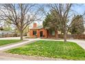 Inviting brick home with a lush green lawn and mature trees, offering great curb appeal at 435 Balsam St, Lakewood, CO 80226