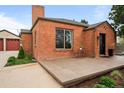 Close-up of brick home showcasing the front patio with outdoor seating and tidy landscaping at 435 Balsam St, Lakewood, CO 80226
