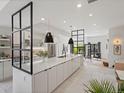 Bright, open-concept kitchen with quartz counters, sleek black pendant lights, and seamless connection to the living room at 4432 Umatilla St, Denver, CO 80211