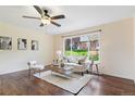 Comfortable living room that features updated ceiling fan and lots of natural light from large window at 12708 W Virginia Ave, Lakewood, CO 80228