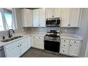 Updated kitchen showcasing stainless steel appliances, quartz countertops, and white cabinetry at 2263 Serenidad St, Brighton, CO 80601